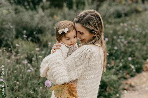 Smiling mother and daughter standing in park photo