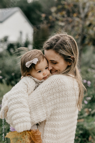 Smiling mother and daughter standing in park