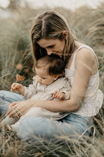Mother and daughter sitting on grass in park
