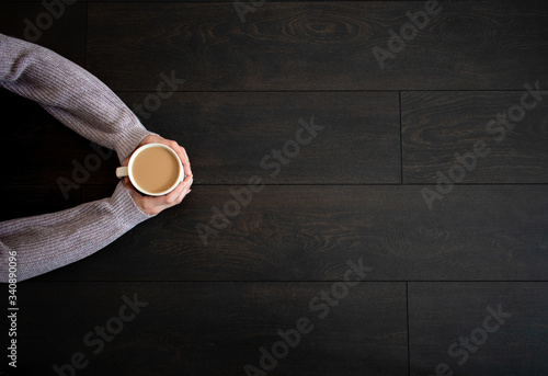Wooden background with coffee in hands. Top view. 