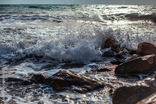 surging waves on a rocky seashore on a sunny day