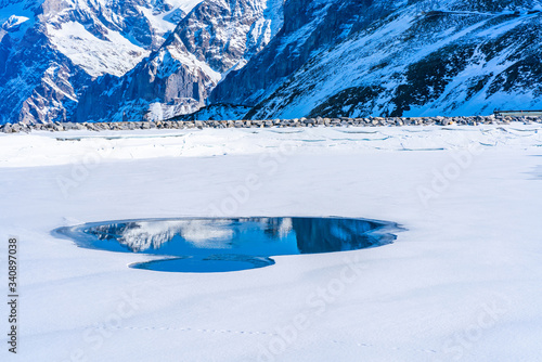 Winter landscape with snow covered peaks and frozen lake on Kleine Scheidegg mountain in Swiss Alps near Grindelwald, Switzerland
