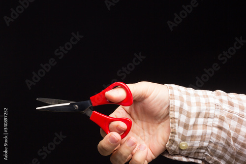Small scissors in the expert hand of an adult photo
