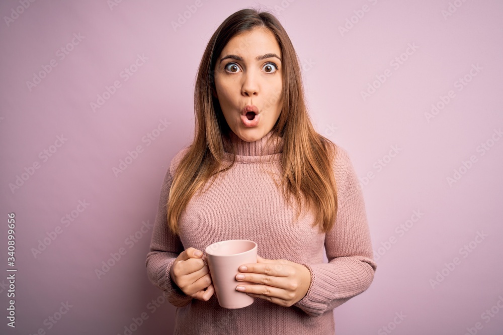 Young blonde woman drinking a cup of coffee over pink isolated background scared in shock with a surprise face, afraid and excited with fear expression Young blonde woman drinking a cup of coffee over pink isolated background scared in shock with a surprise face, afraid and excited with fear expression