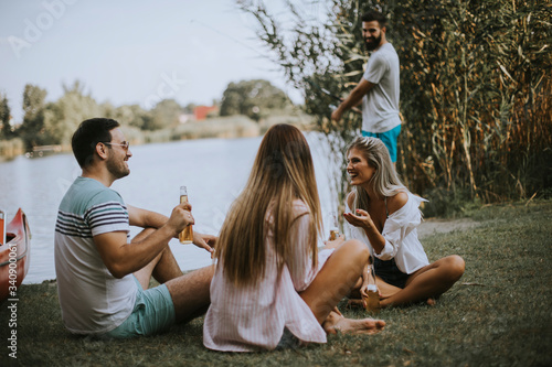 Group of young friends enjoying the nature on the lakeside photo