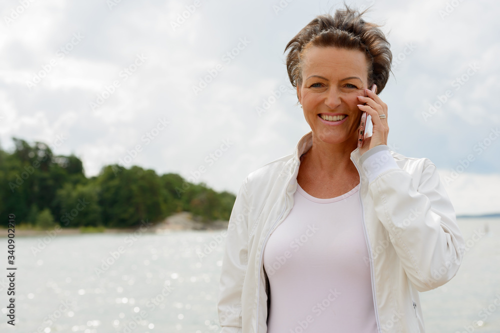 Mature beautiful woman against scenic view of the lake Mature beautiful woman against scenic view of the lake