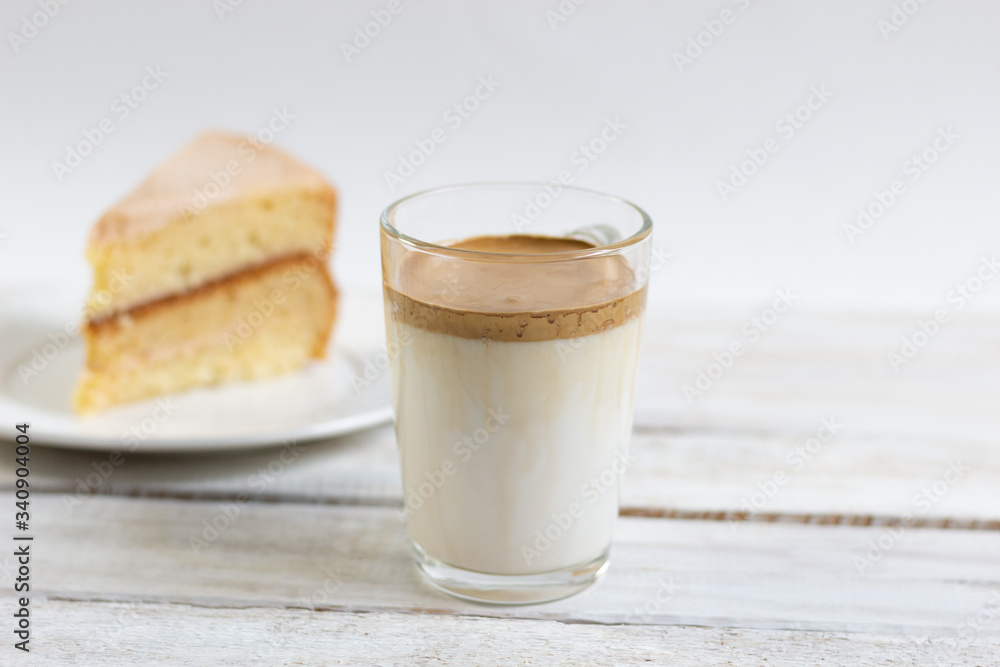 Dalgona coffee in glass cup on white background with honey cream cake piece Dalgona coffee in glass cup on white background with honey cream cake piece