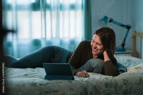 Girl lyin on the bed making video call during quarantine photo