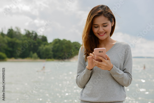 Young beautiful Asian woman against scenic view of the lake