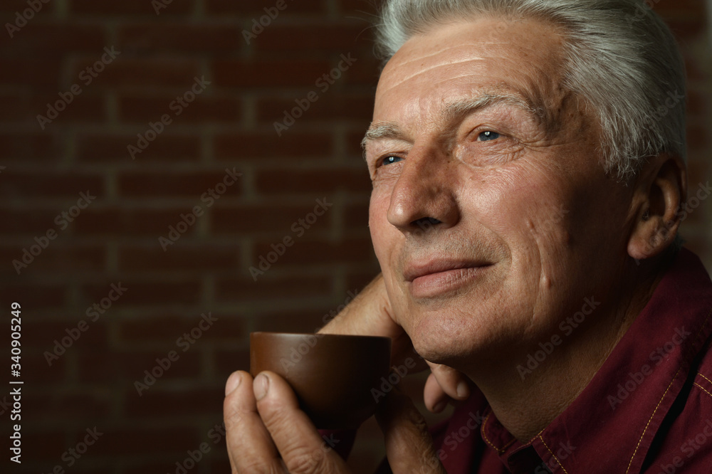 Portrait of smiling senior man drinking coffee at home Portrait of smiling senior man drinking coffee at home