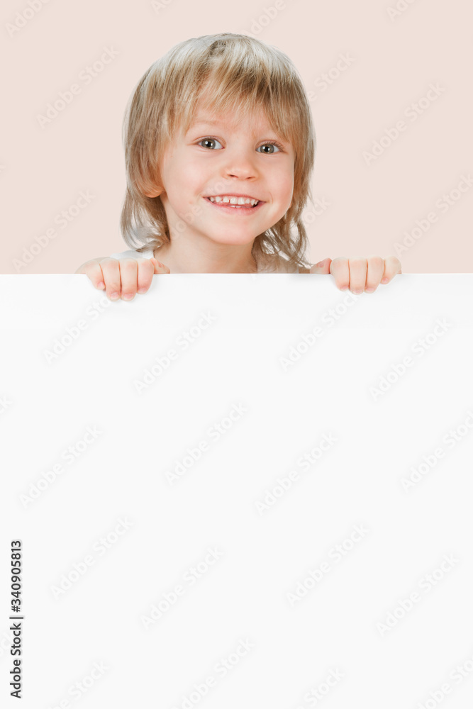 Smiling happy little boy showing blank placard board for text Smiling happy little boy showing blank placard board for text