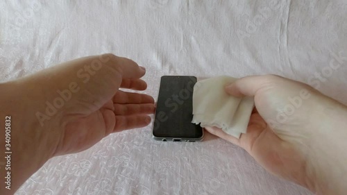 A man disinfects a smartphone with antibacterial wipes during the Covid-19 epidemic