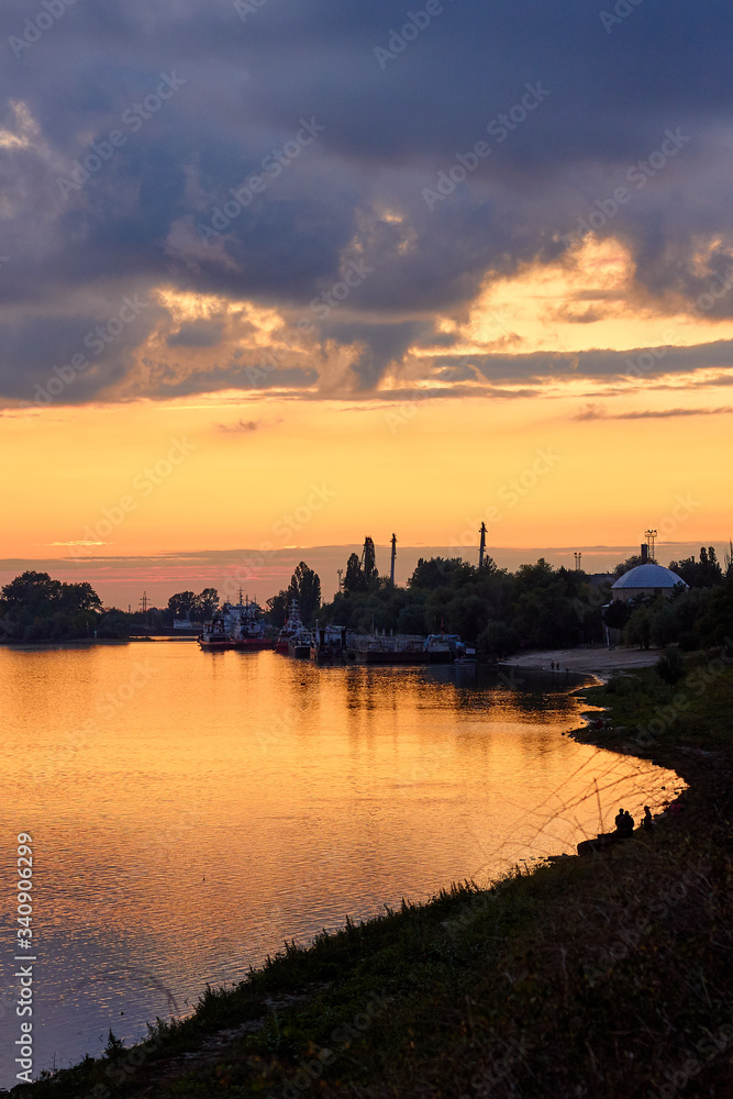 Colorful clouds at sunset over the river in the town