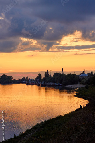 Colorful clouds at sunset over the river in the town