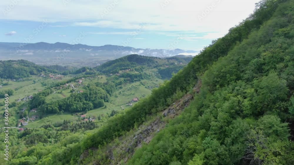 Wide angle dolly in drone shot of beautiful mountains and valleys in Suhi Potok settlement in the Municipality of Kocevje in southern Slovenia Wide angle dolly in drone shot of beautiful mountains and valleys in Suhi Potok settlement in the Municipality of Kocevje in southern Slovenia