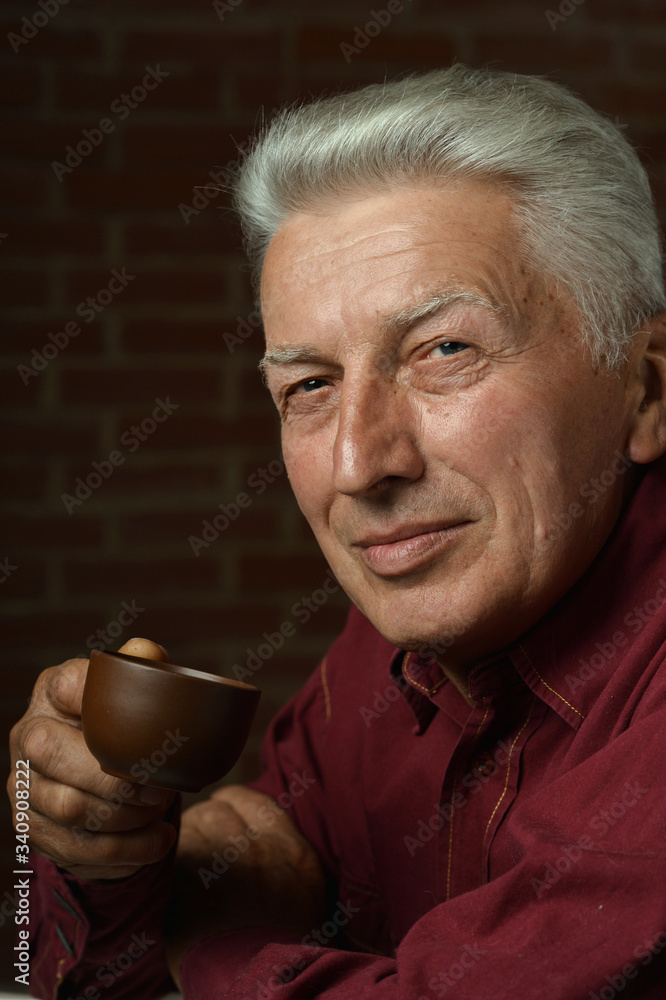 Portrait of smiling senior man drinking coffee at home Portrait of smiling senior man drinking coffee at home