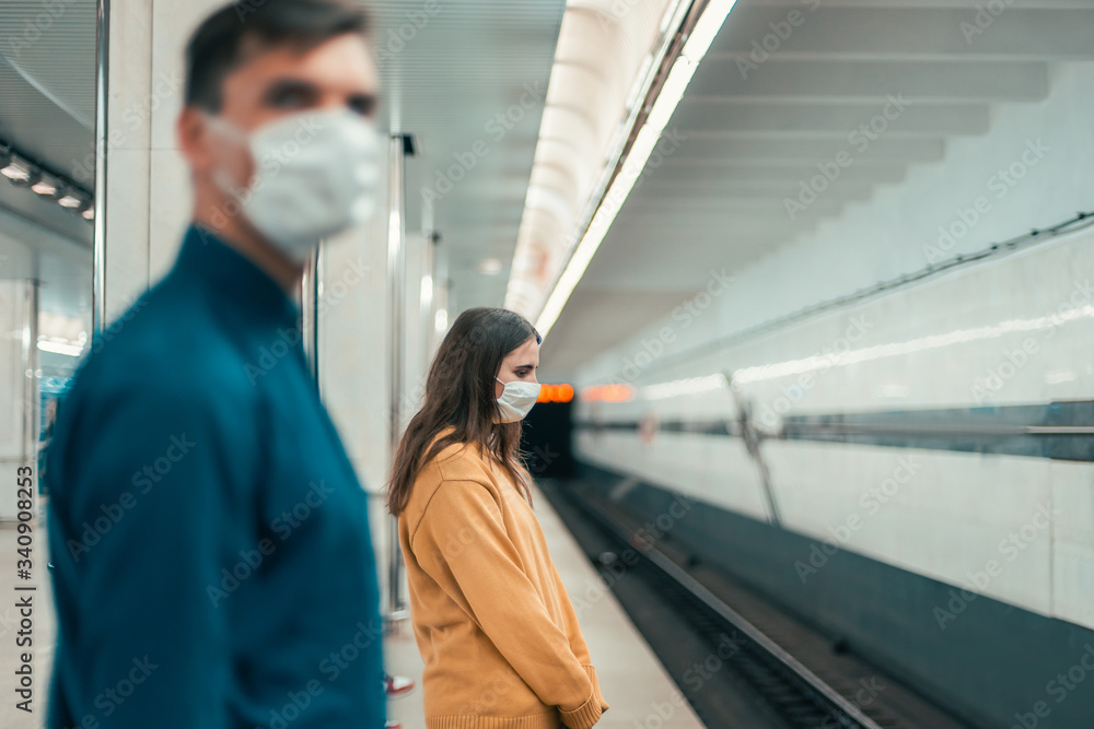 passengers in protective masks standing at the metro station passengers in protective masks standing at the metro station