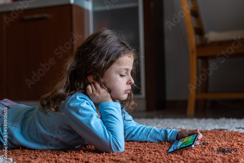 Cute little girl lying down looking at mobile