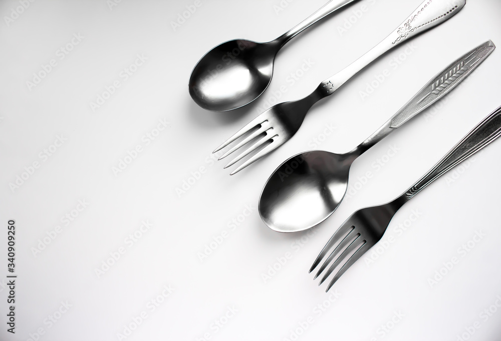 Two spoons and two forks on a white background Two spoons and two forks on a white background