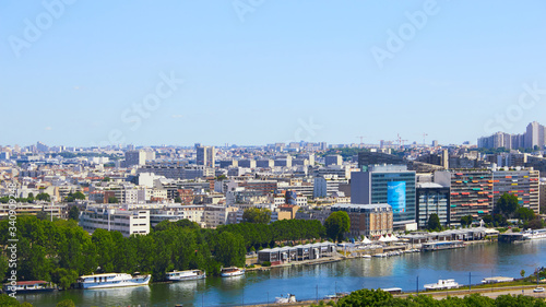 Paris, France - August 26, 2019: Paris from above showcasing the capital city's rooftops, the Eiffel Tower, Paris tree-lined avenues with their haussmannian buildings and Montparnasse tower. 16th