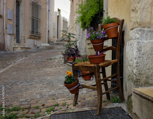 Old vintage chair on the street in the historical center of the city of Arles, Provence, France with beautiful flowers