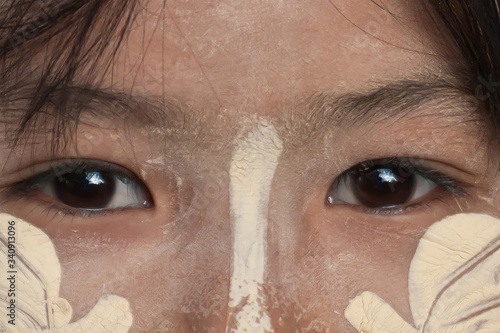 Eyes and part of a face with traditional thanaka powder of an anonymous Burmese girl photo