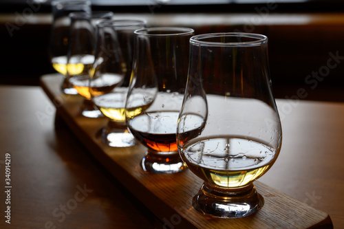 Flight of Scottish whisky, tasting glasses with variety of single malts or blended whiskey spirits on distillery tour in Scotland photo