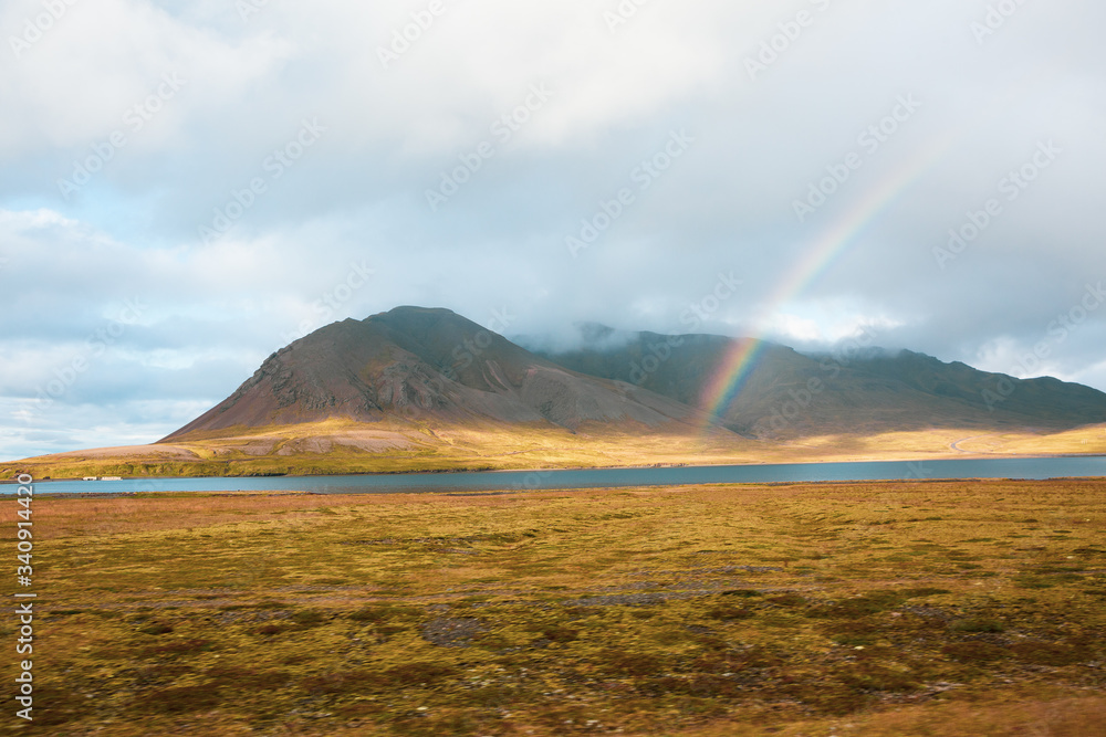 Rainbow in the middle of the golden mountains in Iceland