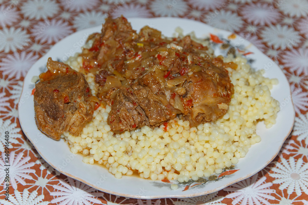 plate on the table with a dish of couscous   with goat meat 