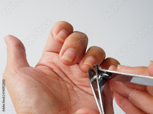 The left fingernail is cut by a nail clippers. The fingernails  harbor dirt and germs and can contribute to the spread of some infections nail, so that the grooming is a important self-care routine.