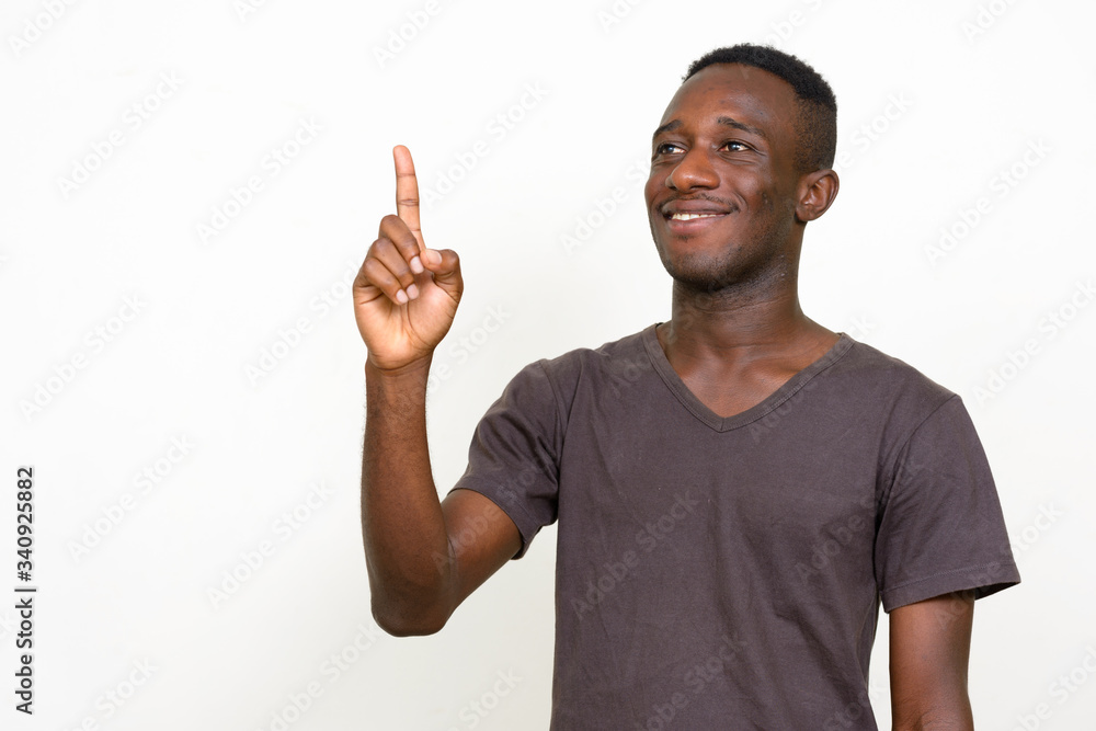 Portrait of happy young African man pointing up Portrait of happy young African man pointing up