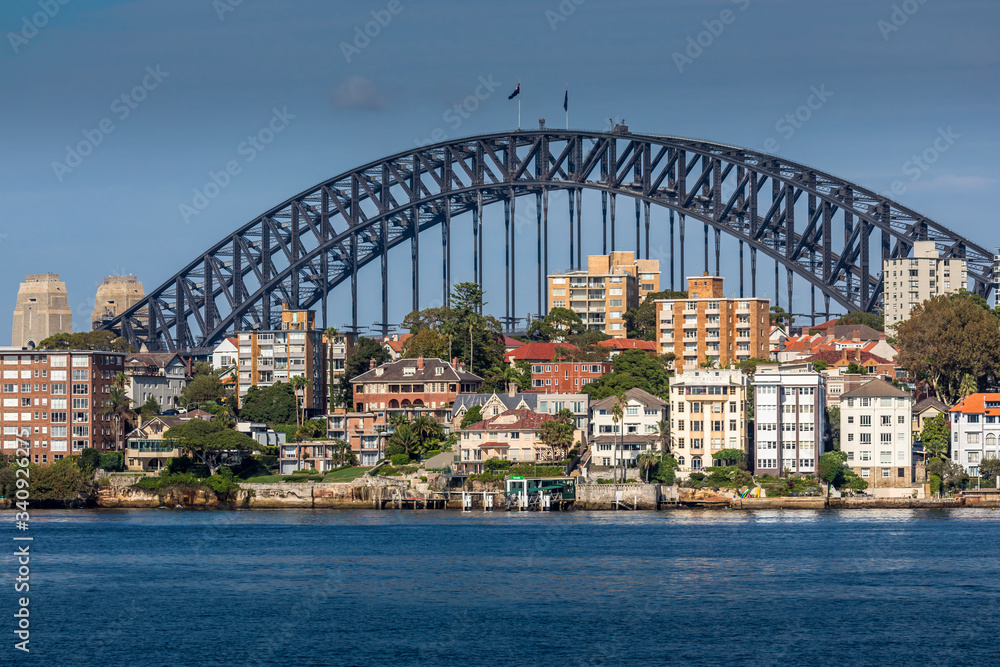 Fototapeta premium Sydney, Australia - 10th February 2020: A German photographer visiting Sydney in Australia, taking pictures of the skyline with the Harbour Bridge during a cloudy but warm day in summer.