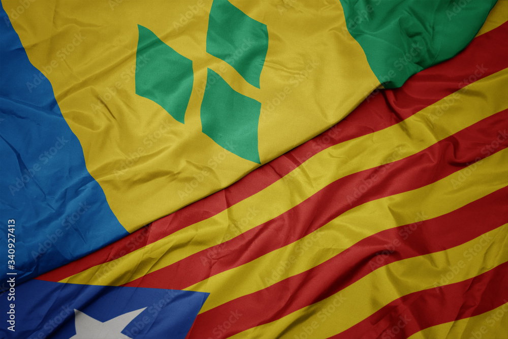 waving colorful flag of catalonia and national flag of saint vincent and the grenadines.
