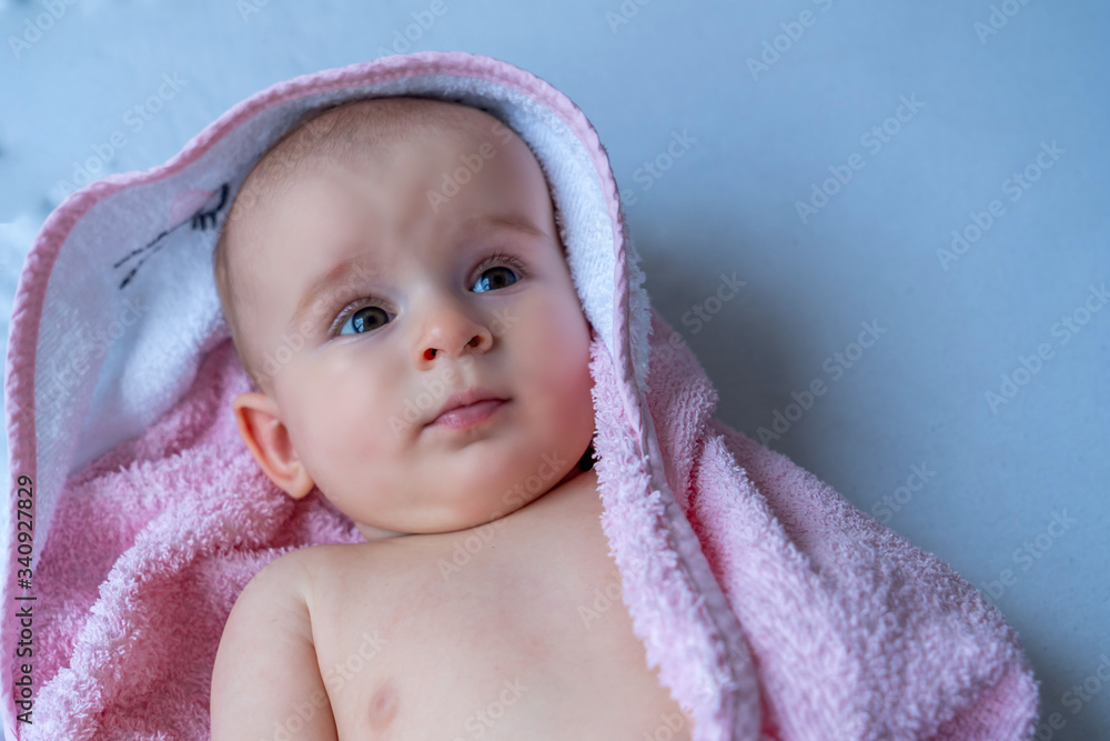Six month baby girl wearing towel after bath. Childhood and baby care concept Six month baby girl wearing towel after bath. Childhood and baby care concept
