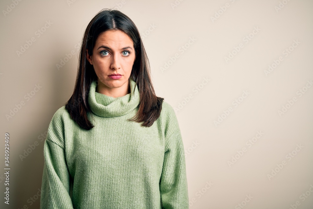 Young brunette woman with blue eyes wearing turtleneck sweater over white background depressed and worry for distress, crying angry and afraid. Sad expression. Young brunette woman with blue eyes wearing turtleneck sweater over white background depressed and worry for distress, crying angry and afraid. Sad expression.