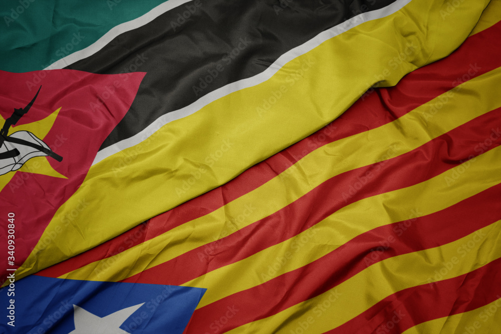 waving colorful flag of catalonia and national flag of mozambique.