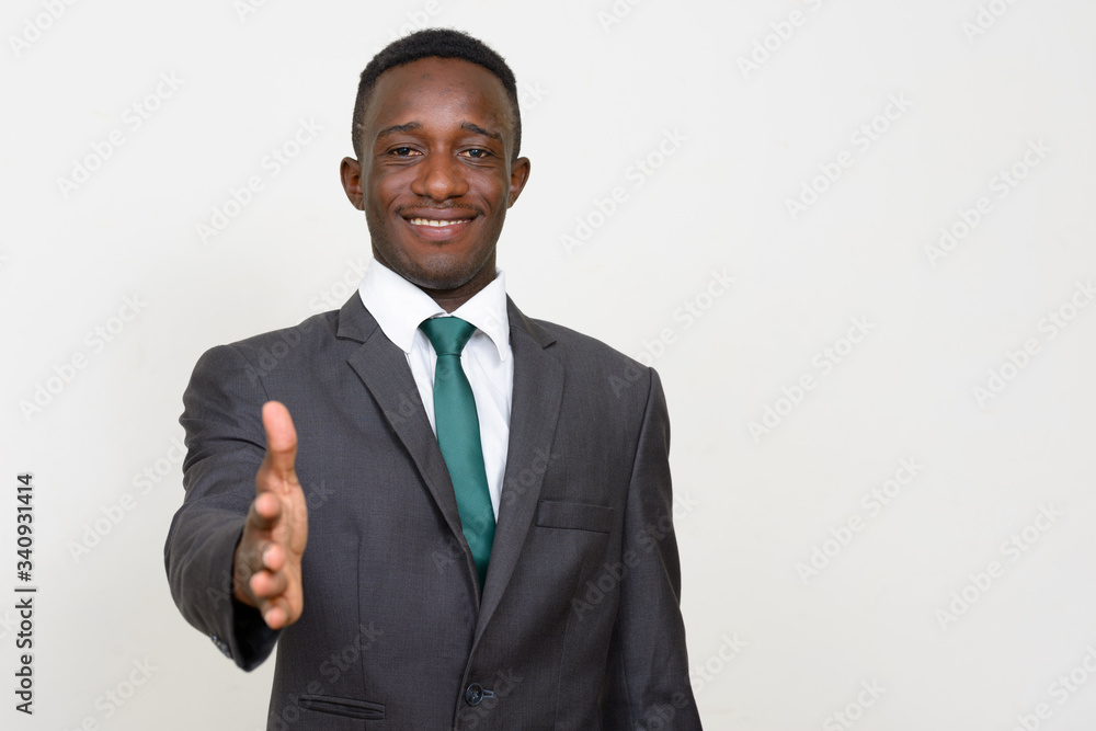 Portrait of happy young African businessman in suit giving handshake Portrait of happy young African businessman in suit giving handshake