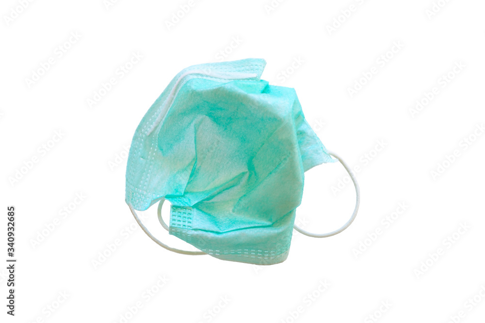 Used green medical surgical mask, Medical protective mask on white background. Disposable surgical face mask cover the mouth and nose. Selective focus. Used green medical surgical mask, Medical protective mask on white background. Disposable surgical face mask cover the mouth and nose. Selective focus.