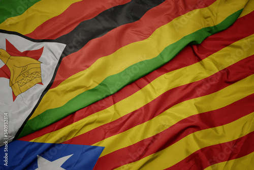 waving colorful flag of catalonia and national flag of zimbabwe.