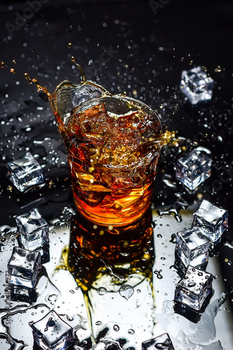 Whiskey with ice cubes on black background from above.Glass of scotch and ice cubes on a on black background