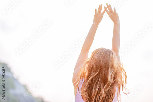 Photography Pregnant woman practices yoga, standing in vrksasana position on the beach, on the rocks