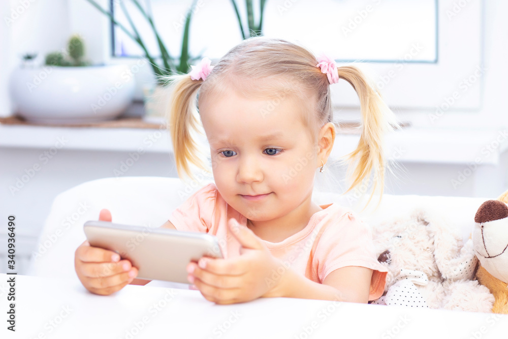 Girl using a mobile phone, a smartphone for video calls, talking with relatives, a girl sitting at home, online computer webcam, making a video call. Girl using a mobile phone, a smartphone for video calls, talking with relatives, a girl sitting at home, online computer webcam, making a video call.