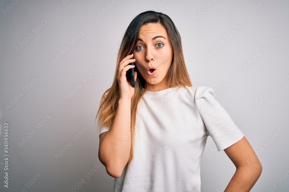 Young beautiful brunette woman having conversation talking on the smartphone scared in shock with a surprise face, afraid and excited with fear expression Young beautiful brunette woman having conversation talking on the smartphone scared in shock with a surprise face, afraid and excited with fear expression
