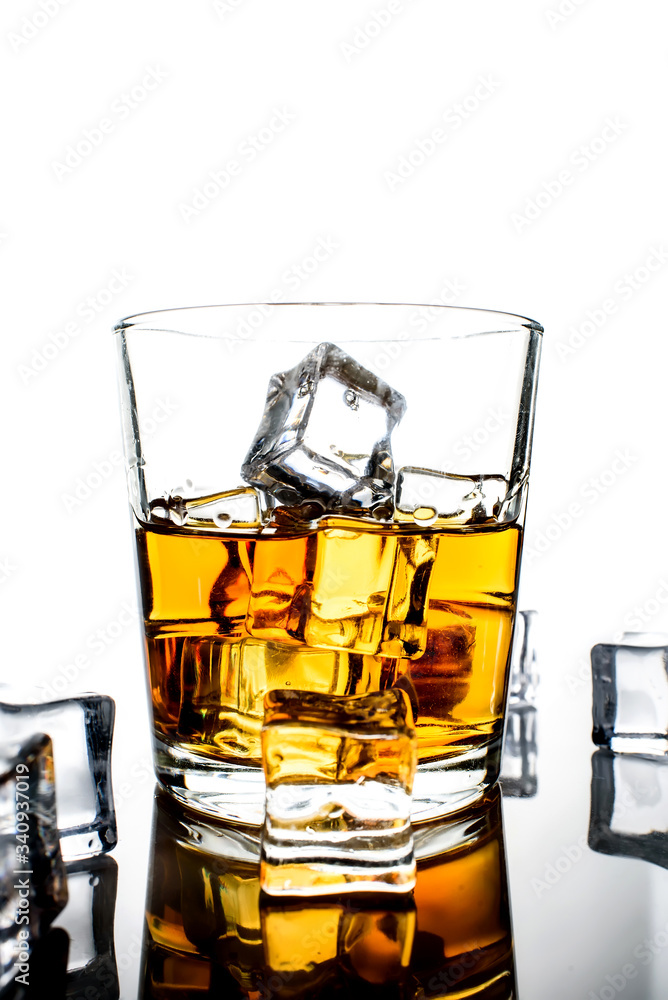 Whiskey with ice cubes.Isolated shot of whiskey.Glass of scotch and ice cubes on a white background. Whiskey with ice cubes.Isolated shot of whiskey.Glass of scotch and ice cubes on a white background.