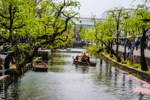 Japanese people riding a small boat on the river in Kurashiki town, Japan