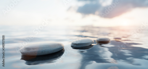 Zen stones on calm water at sunset. Spa wellness and harmony.