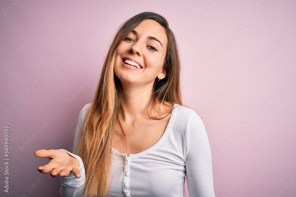 Young beautiful blonde woman with blue eyes wearing white t-shirt over pink background smiling cheerful with open arms as friendly welcome, positive and confident greetings Young beautiful blonde woman with blue eyes wearing white t-shirt over pink background smiling cheerful with open arms as friendly welcome, positive and confident greetings