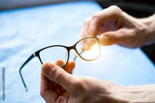 Glasses in hands. Man`s hands holding eyesight glasses. Modern eyewear. Correcting eyesight.