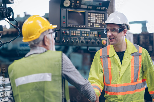 worker standing  with mentor hand shake  in factory
