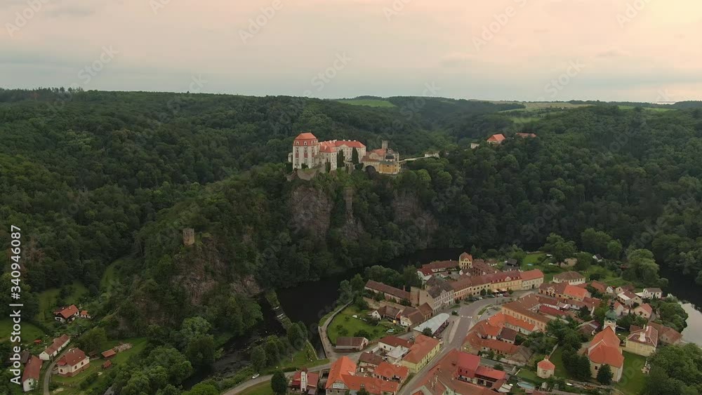 Aerial view of Vranov nad Dyji castle. Ancient fortress placed on big rock above hill and small city. Cloudy weather during sunset. Aerial view of Vranov nad Dyji castle. Ancient fortress placed on big rock above hill and small city. Cloudy weather during sunset.